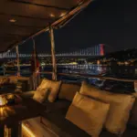 Illuminated Ottoman palace on the Bosphorus shore seen from a yacht deck at night